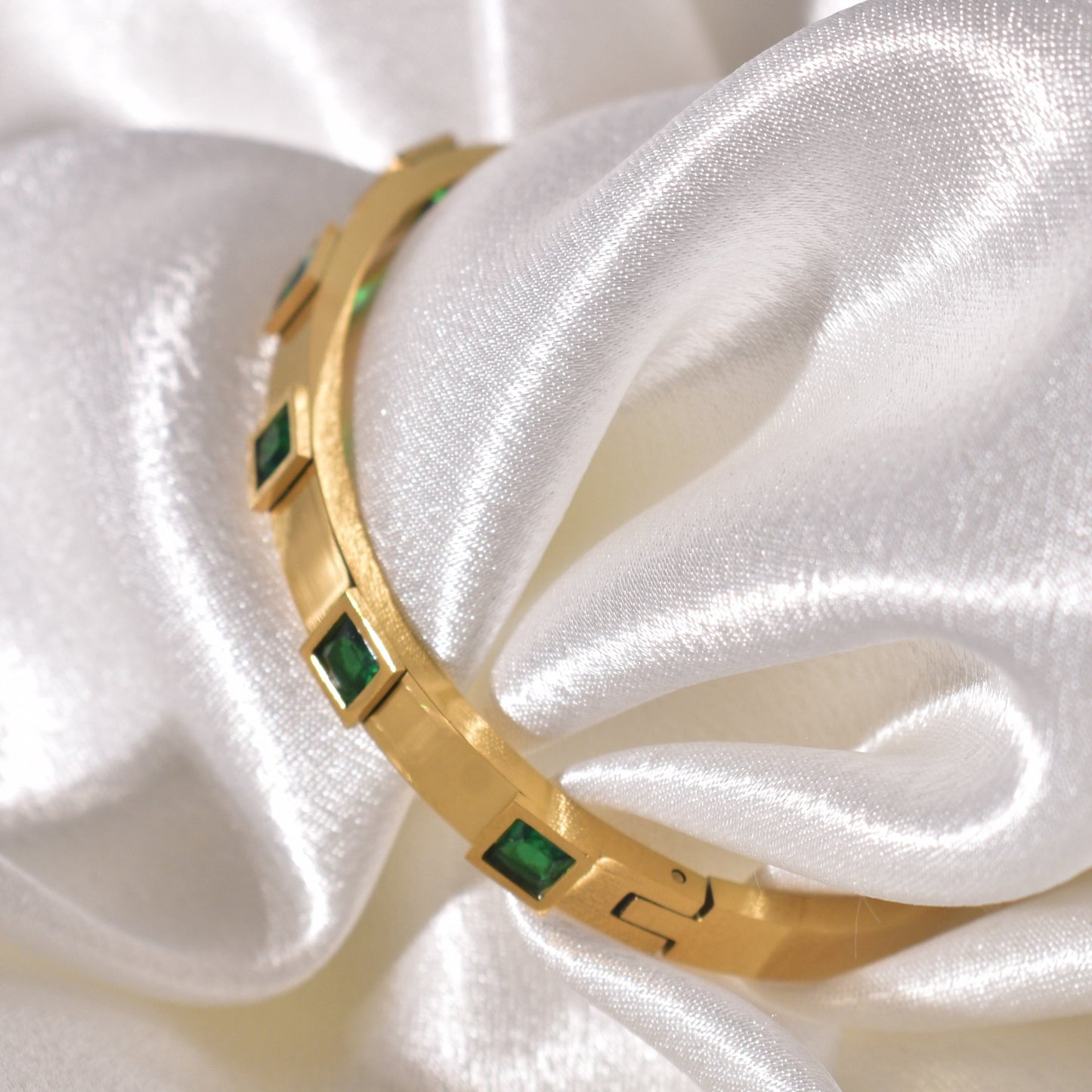 Emerald green square stones set in a luxurious gold-plated bracelet