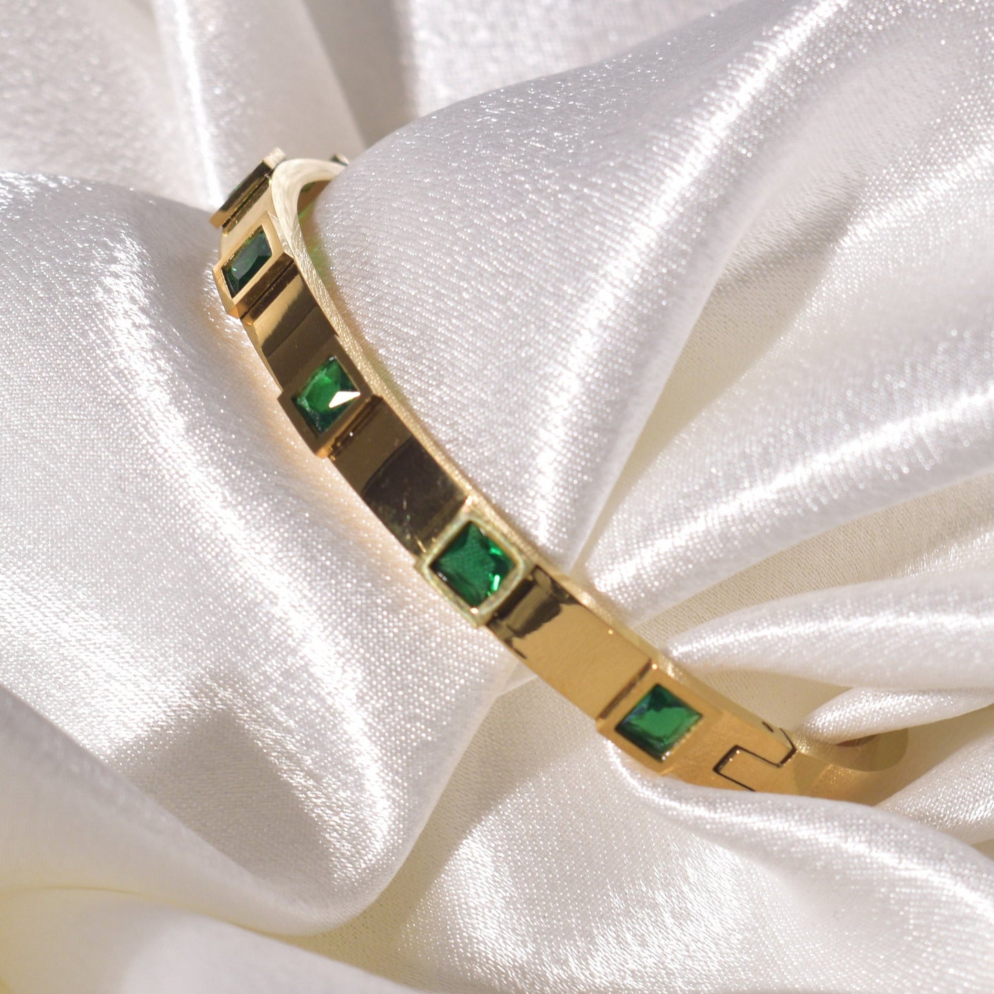 Emerald green square stones set in a luxurious gold-plated bracelet