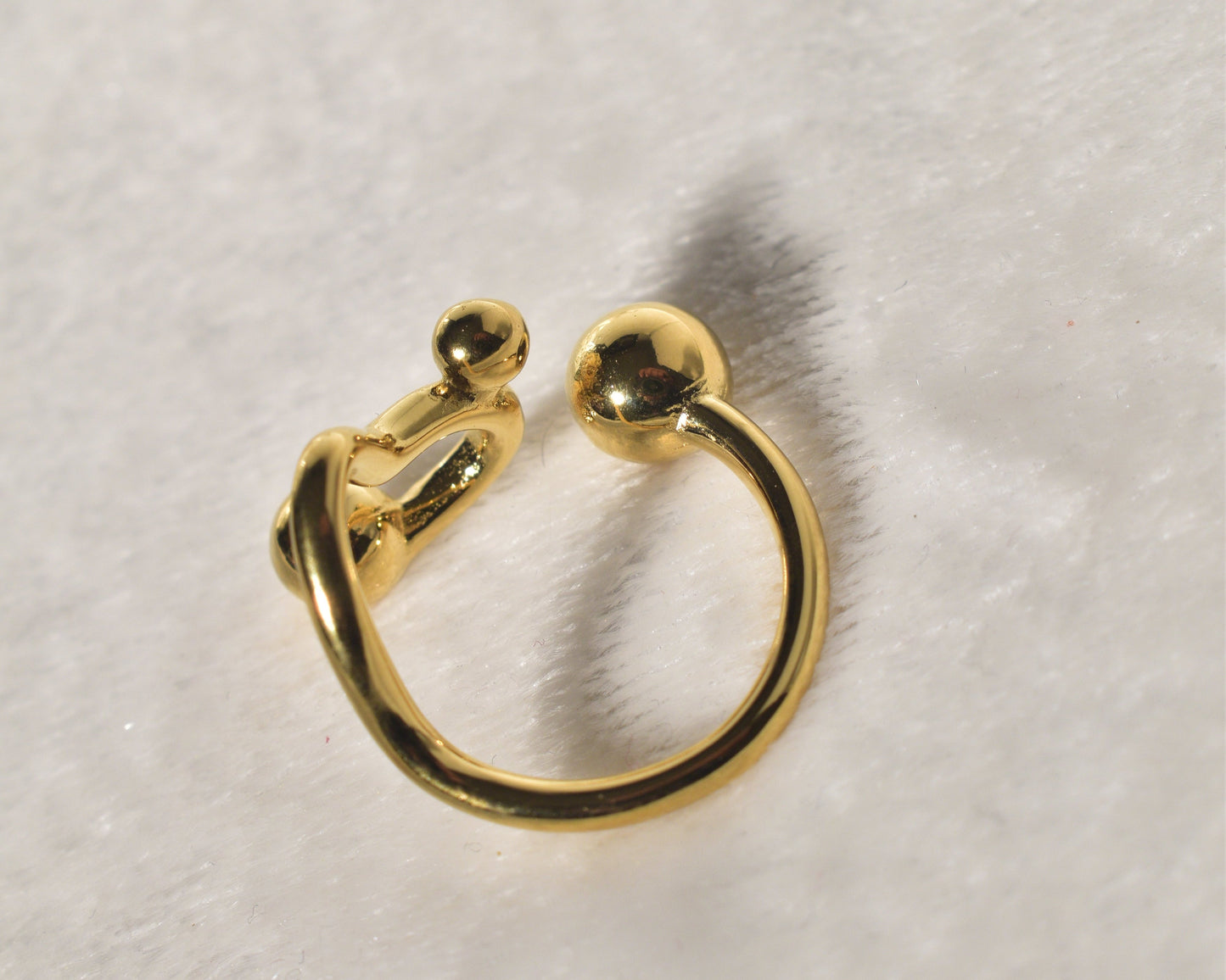 A contemporary and distinctive statement piece is the Wavy Gold Ball Ring.